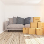 Kleiner Raum mit Sofa und Kartons.